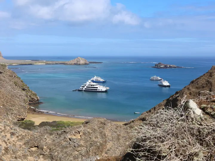 Cruise yachts at anchor in a bay seen from the cliff trail, San Cristóbal