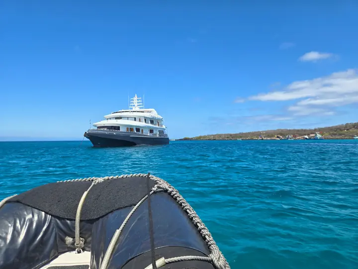 Panga approaching a cruise yacht at anchor, San Cristóbal
