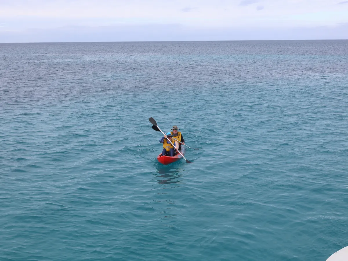 A lone kayaker on turquoise water during a Galápagos cruise